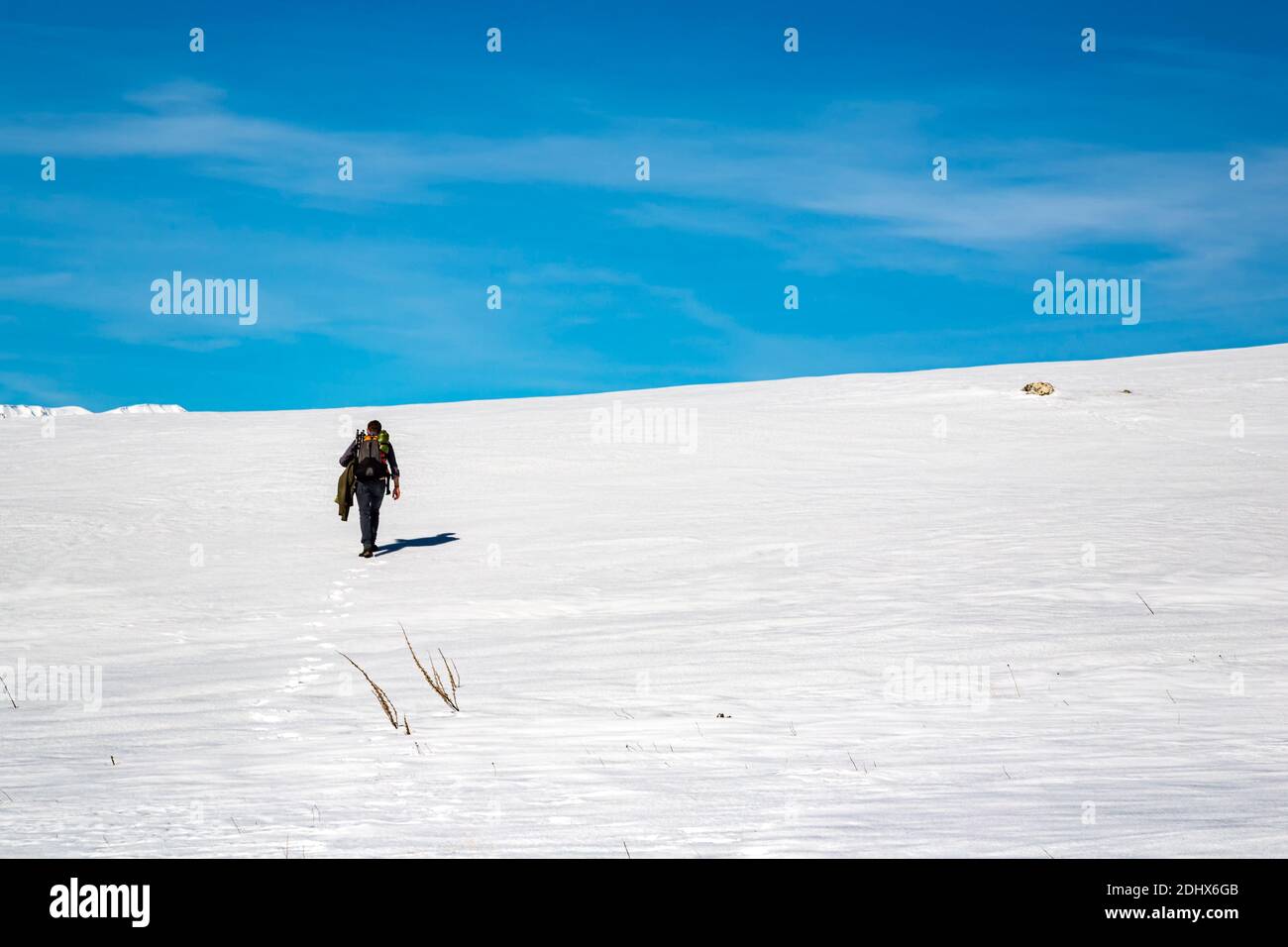 Il fotografo escursionista raggiunge il punto di scattare una foto. Catena montuosa del Gran Sasso, campo Imperatore. Abruzzo, Italia, Europa Foto Stock