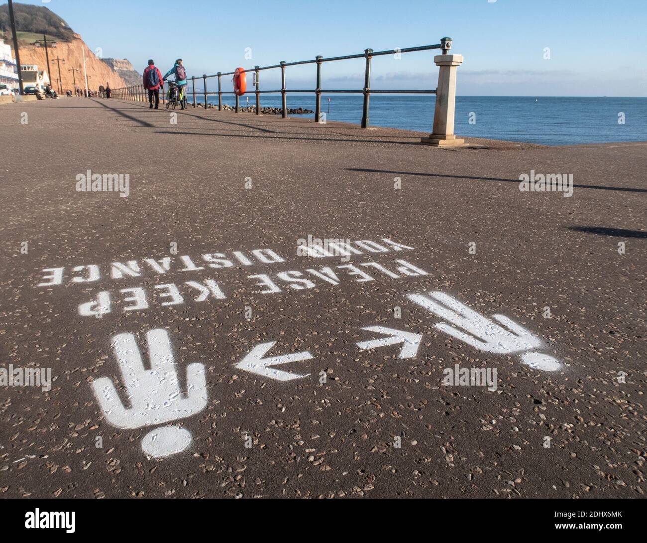 Tieni i cartelli della distanza, a distanza sociale, dipinti sull'Esplanade a Sidmouth, Devon, Inghilterra, Regno Unito Foto Stock