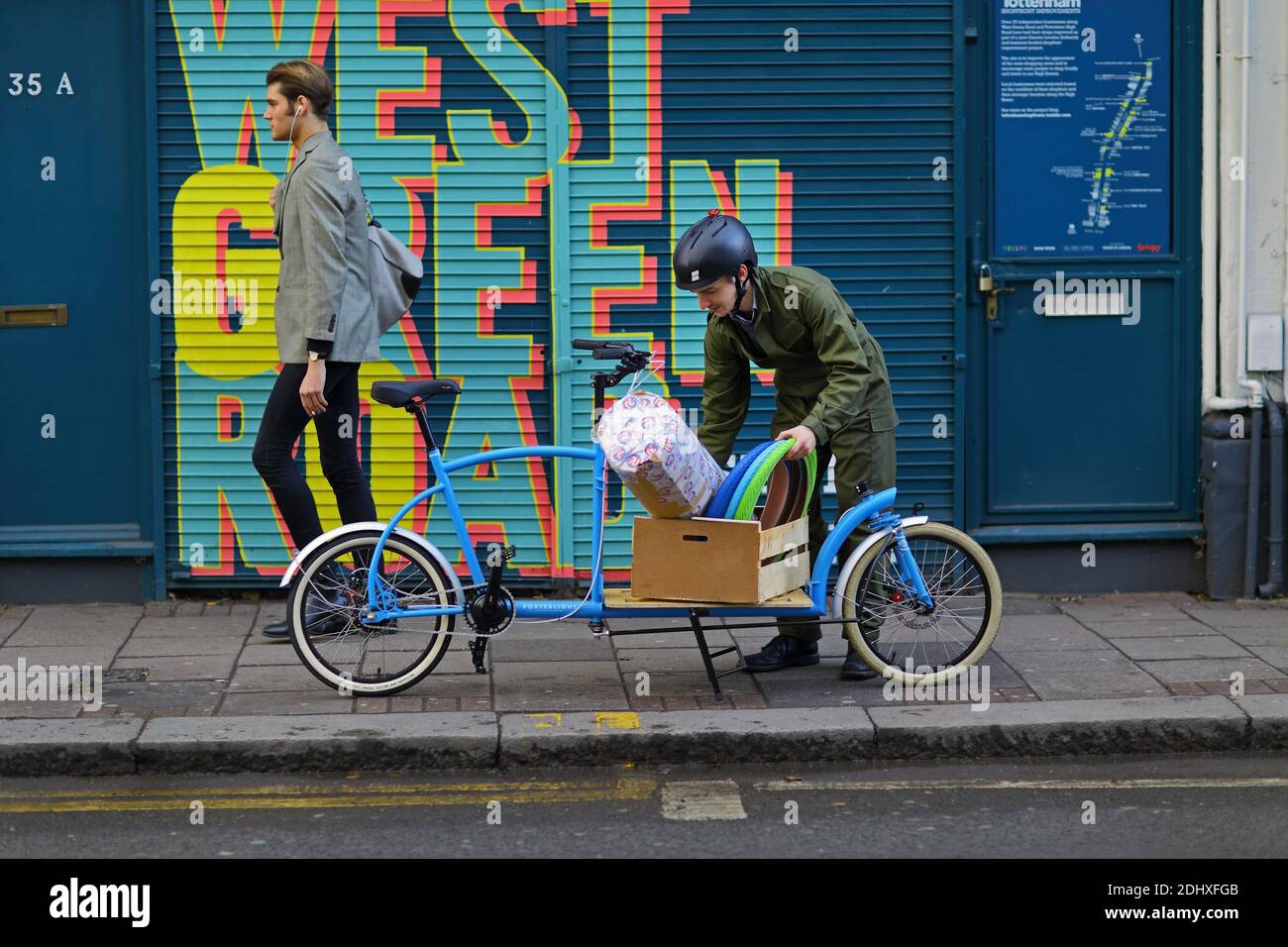 Il corriere del ciclo sta trasportando con la bici del carico, Londra, Regno Unito Foto Stock