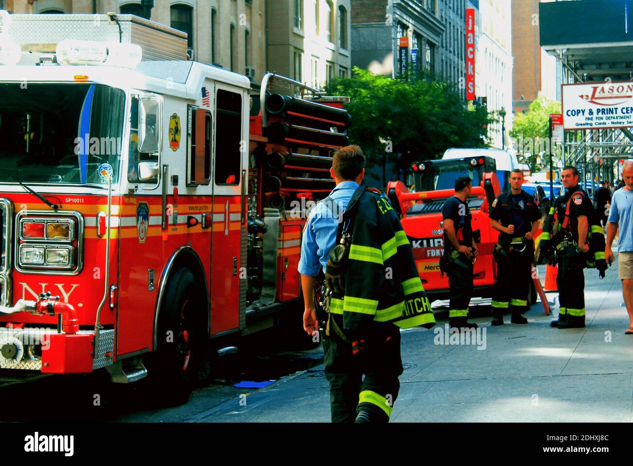 Un capitano del fuoco della FDNY si allontana dalla fotocamera verso il suo equipaggio motore dopo un falso allarme in città Di New York Foto Stock