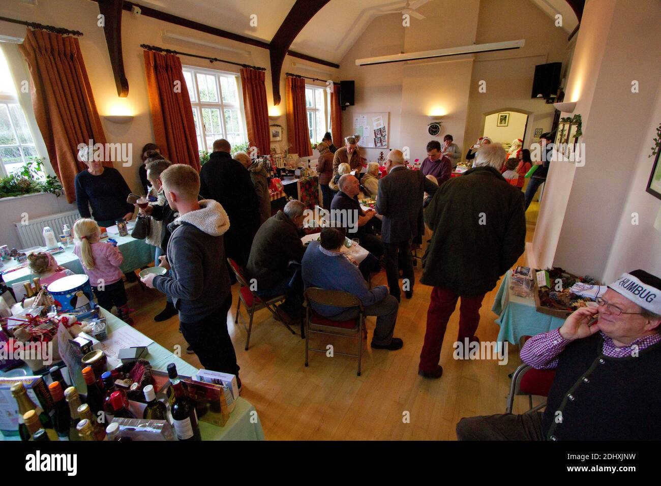 Persone che godono di una fiera di Natale raccolta fondi per la carità in Una sala villaggio Suffolk Foto Stock