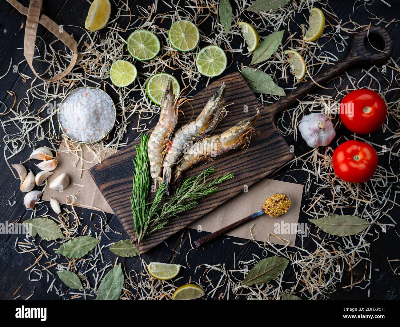 Gamberetti freschi su tavola da cucina con ingredienti. Gamberi crudi, pomodori, sale, lime e aglio Foto Stock