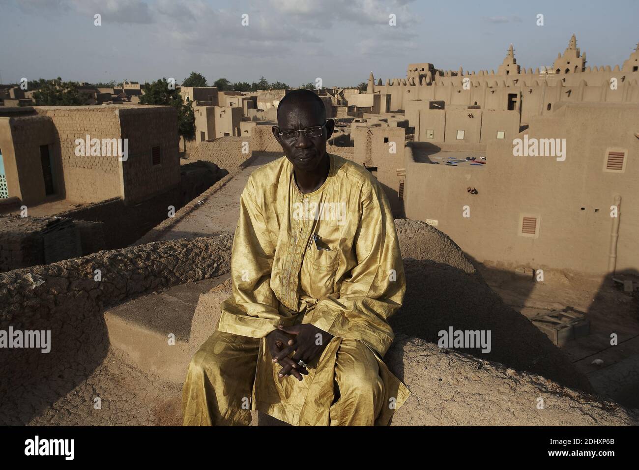 Architetto Maliano specialista in architettura di fango seduto sul tetto in Djenne Mali Africa occidentale Foto Stock
