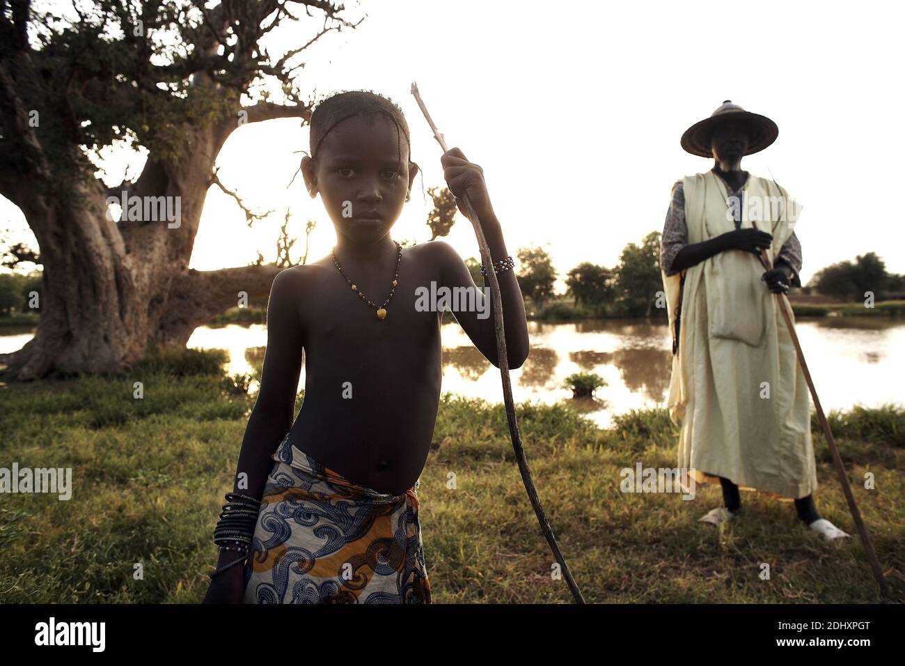 Fulani uomo con un cappello tradizionale e ragazzo vicino al lago in Mali, Africa occidentale. Foto Stock