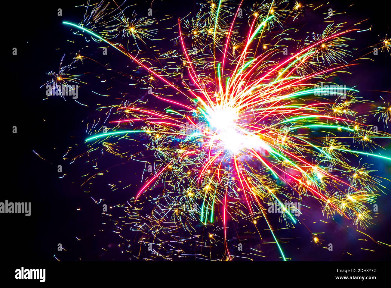 I fuochi d'artificio colorati appaiono nel cielo notturno scuro. Foto Stock