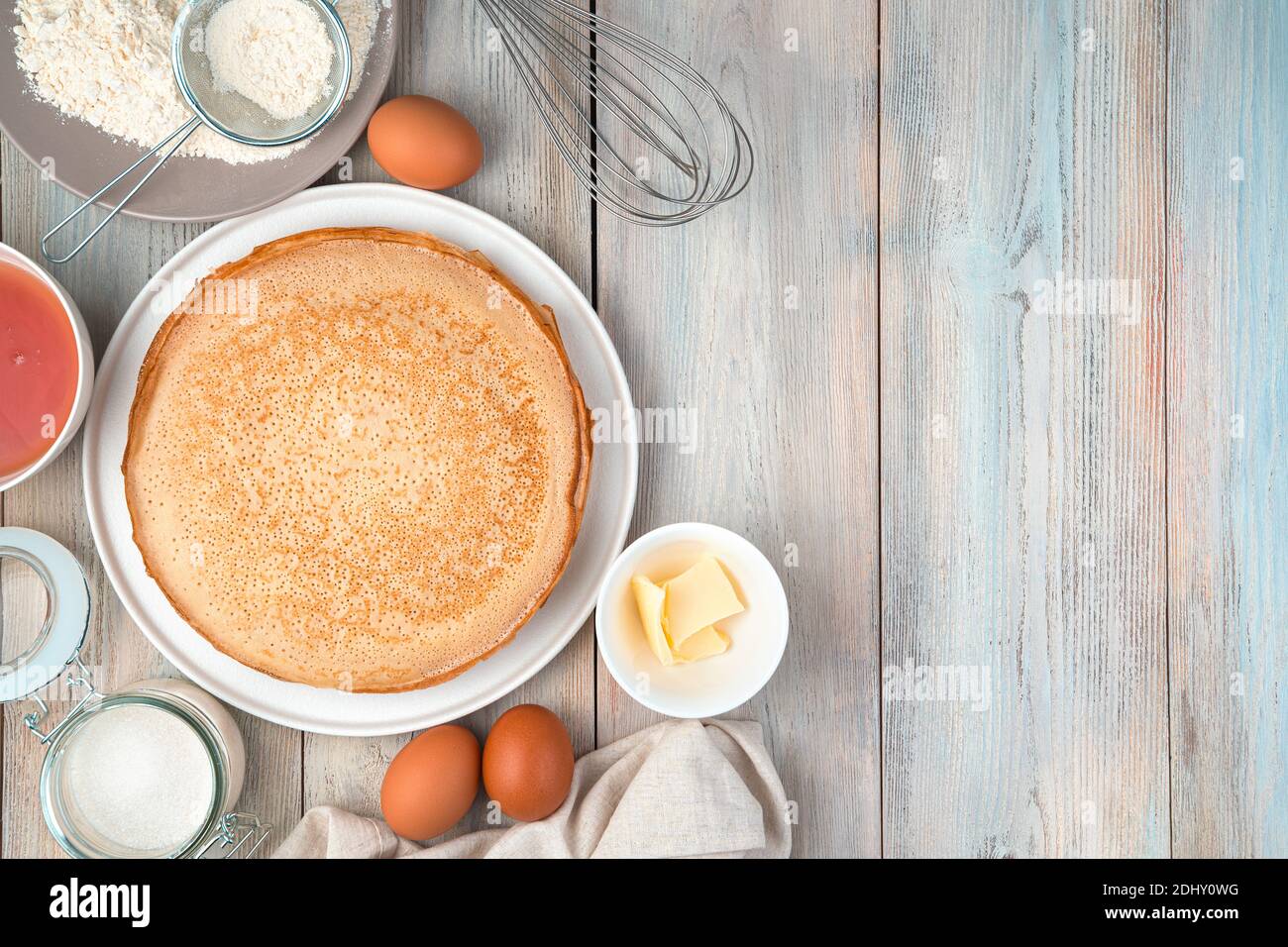 Piatto con frittelle, uova, farina, burro, miele su sfondo chiaro. Foto Stock