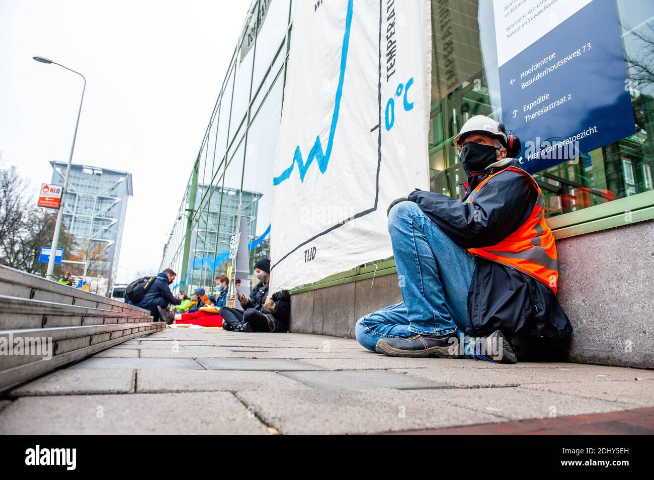 Un attivista è visto tenere un banner durante la dimostrazione.gli attivisti del clima della ribellione estinzione hanno scalato il Ministero degli Affari economici e della politica del clima quartier generale, disfurando un enorme banner di avvertimento di un'emergenza climatica e verniciatura a spruzzo sulle finestre, il giorno del quinto anniversario dell'accordo di Parigi sul clima. Oltre a Parigi, la ribellione estinzione richiede emissioni nette di CO2 pari a zero entro il 2025. Dopo alcune ore, la polizia si è trasferita per rimuovere e trattenere gli attivisti del clima che hanno scalato l'edificio e quelli seduti sul pavimento. Foto Stock