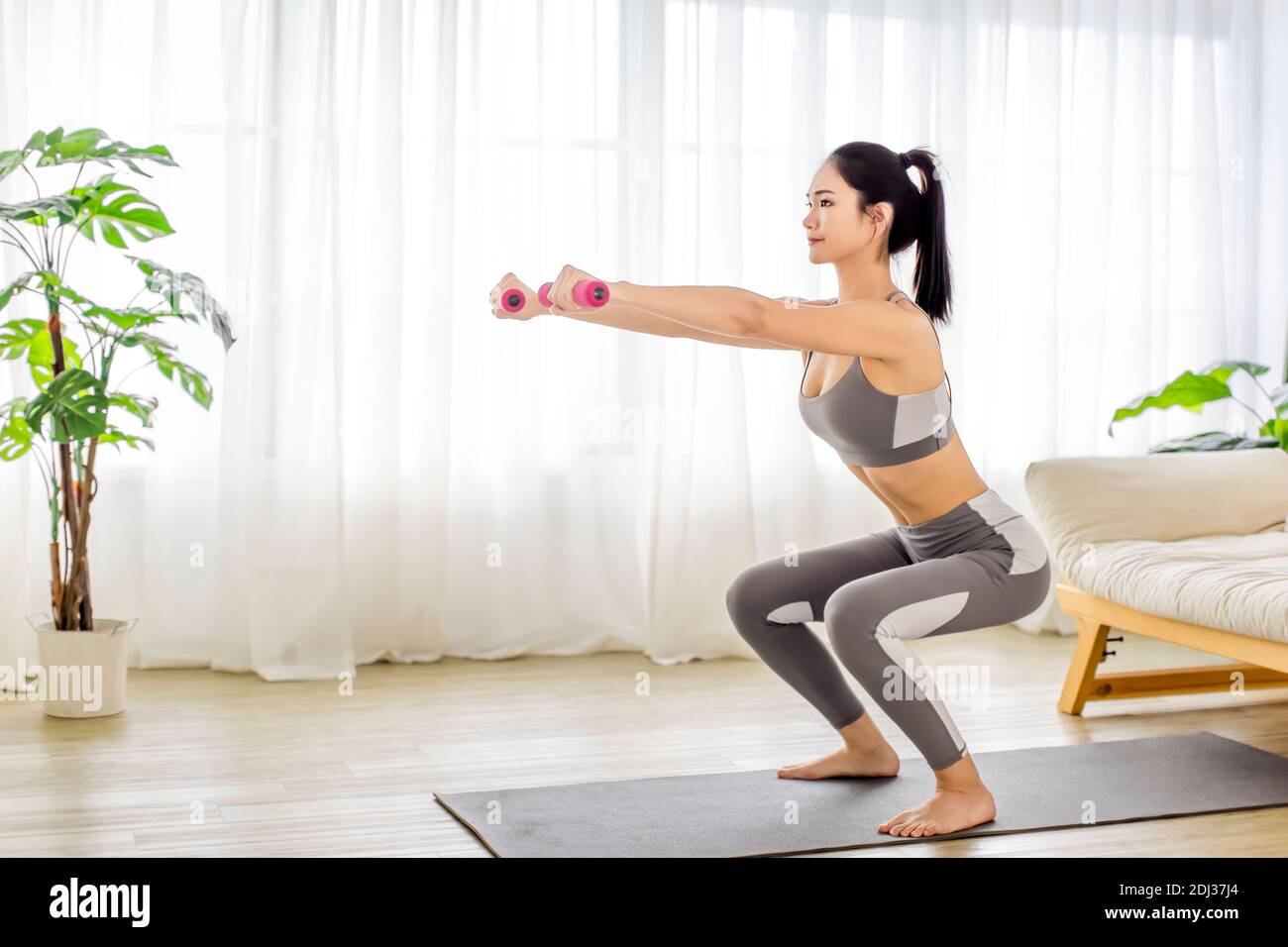 giovane donna in abbigliamento sportivo che fa esercizi di stretching fitness a casa Foto Stock