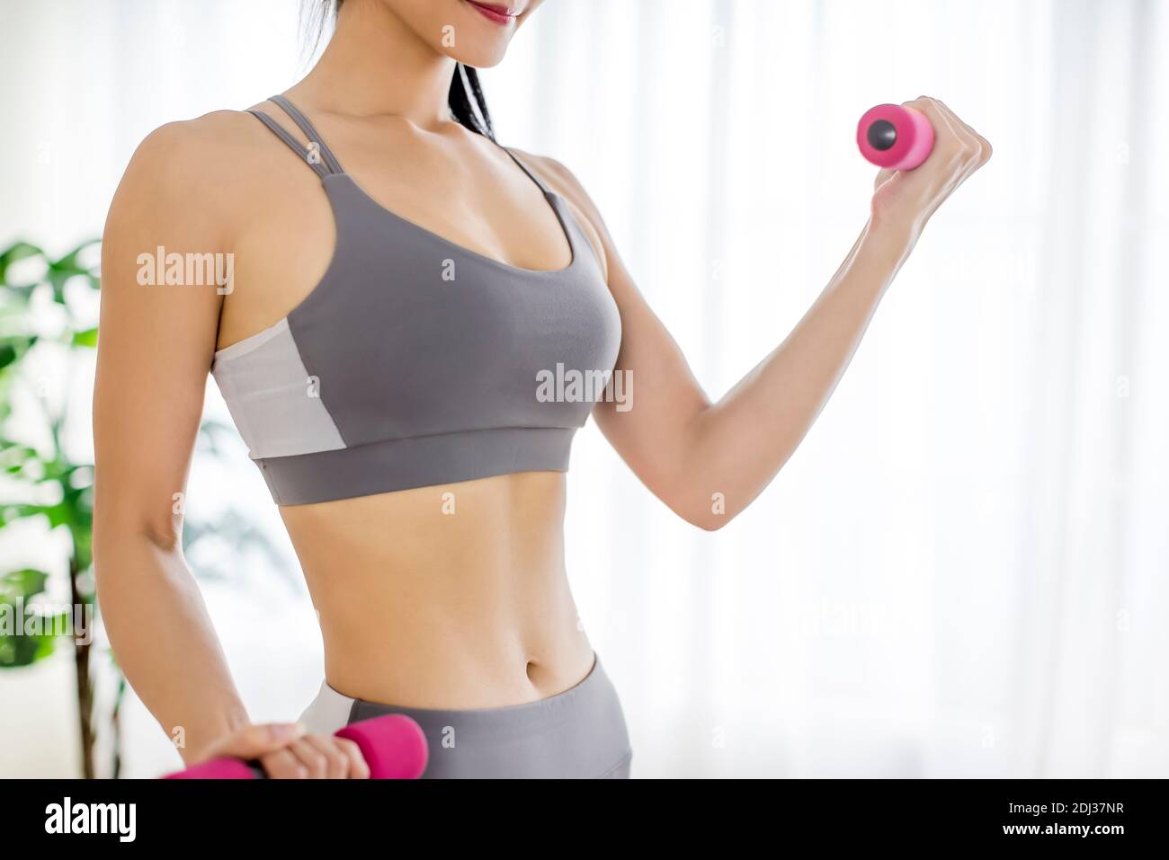 giovane donna in abbigliamento sportivo facendo esercizi di fitness con manubri e. con abs Foto Stock