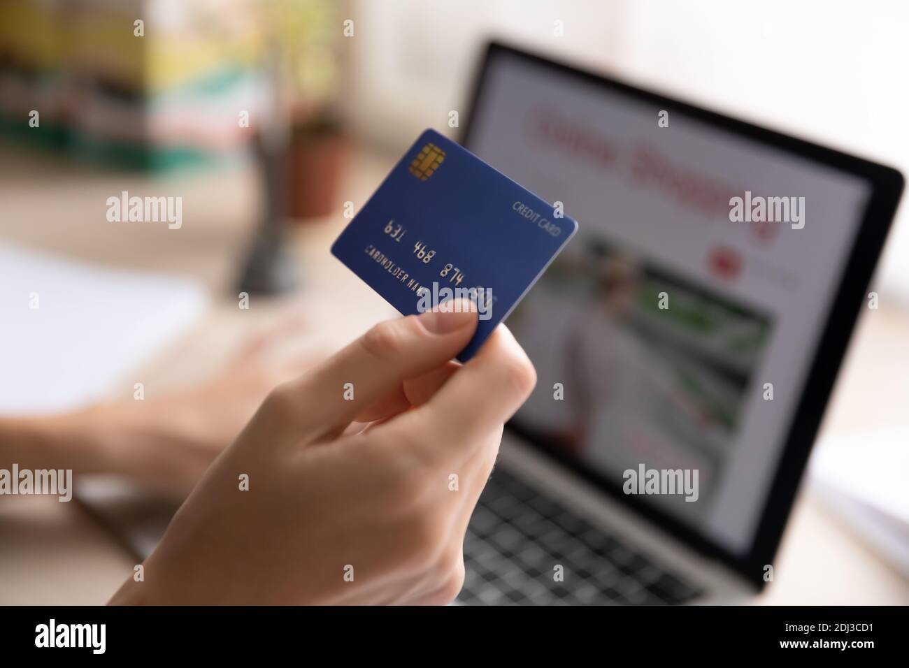 Primo piano donna che tiene la carta di credito di plastica, utilizzando il computer portatile Foto Stock
