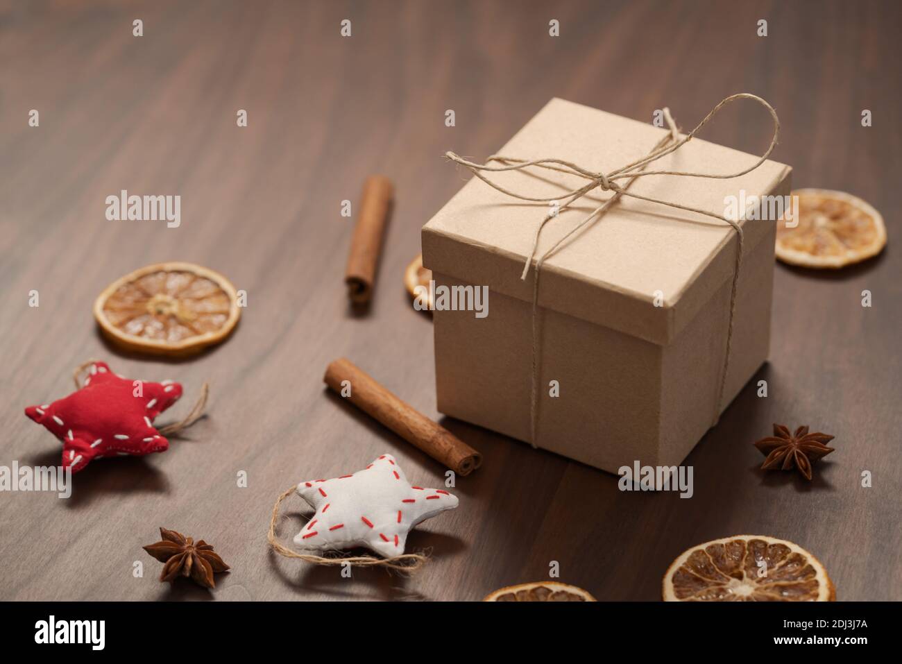 Confezione regalo di Natale di carta ecologica avvolta con spago naturale su tavola di legno con decorazioni naturali, messa a fuoco superficiale Foto Stock