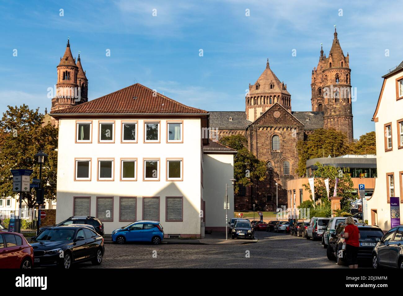 Edifici, persone e un parcheggio intorno alla Cattedrale di San Pietro a Worms, Germania. Foto Stock