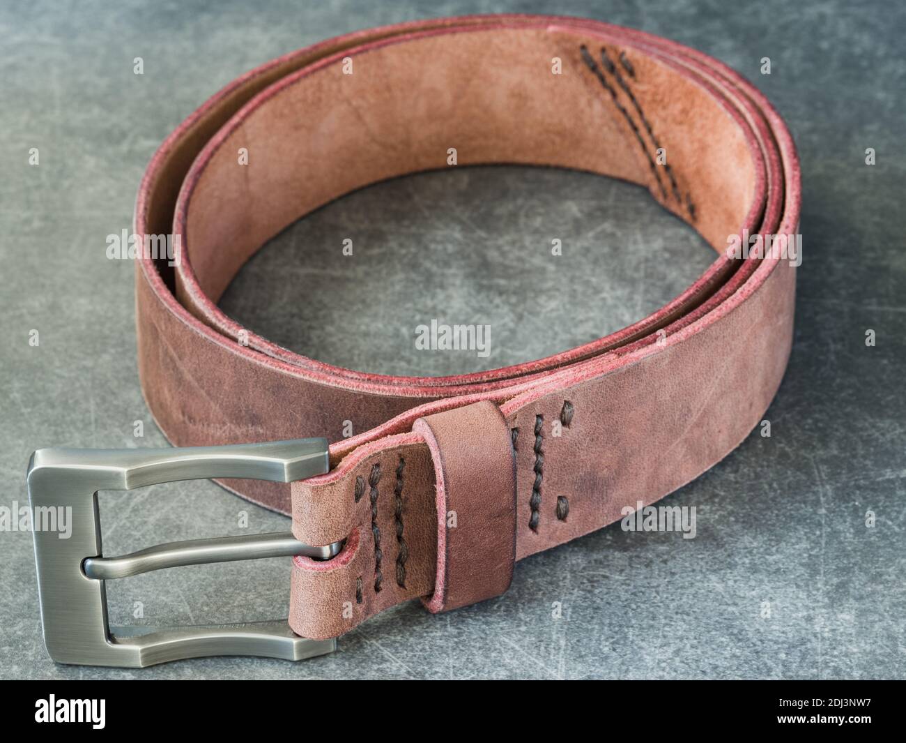 Cintura marrone in vera pelle marrone realizzata a mano su grigio Sfondo Foto Stock