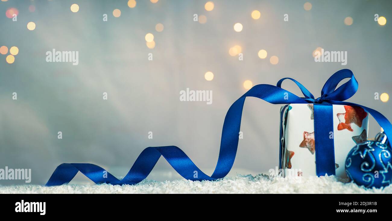 Regalo di Natale avvolto con ambiente di sfondo illuminato festivo e copia spazio Foto Stock