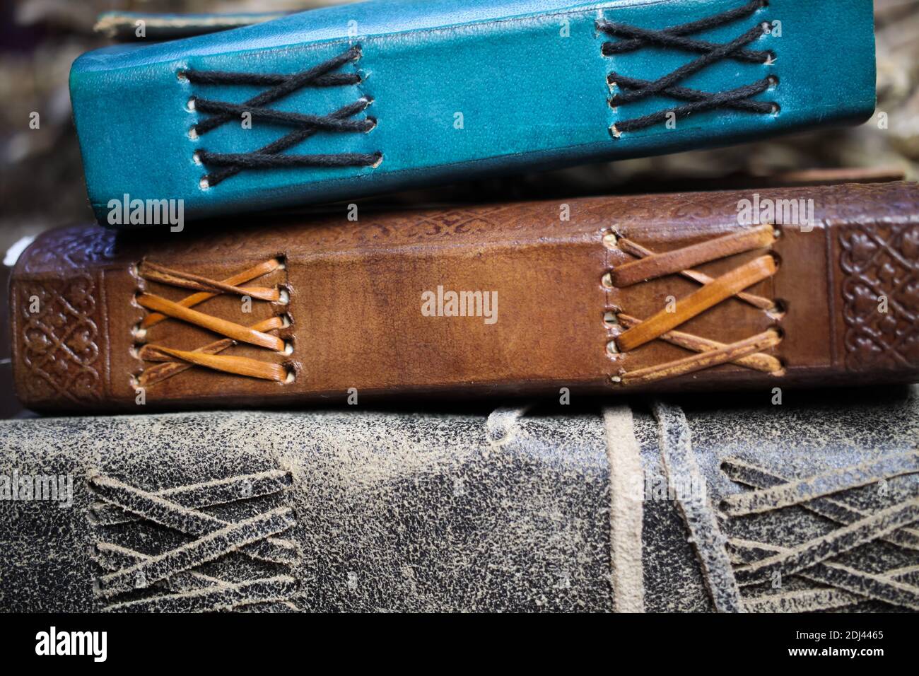 Primo piano della colonna vuota isolata di tre vecchi libri in blu e marrone con rilegatura in pelle vintage Foto Stock