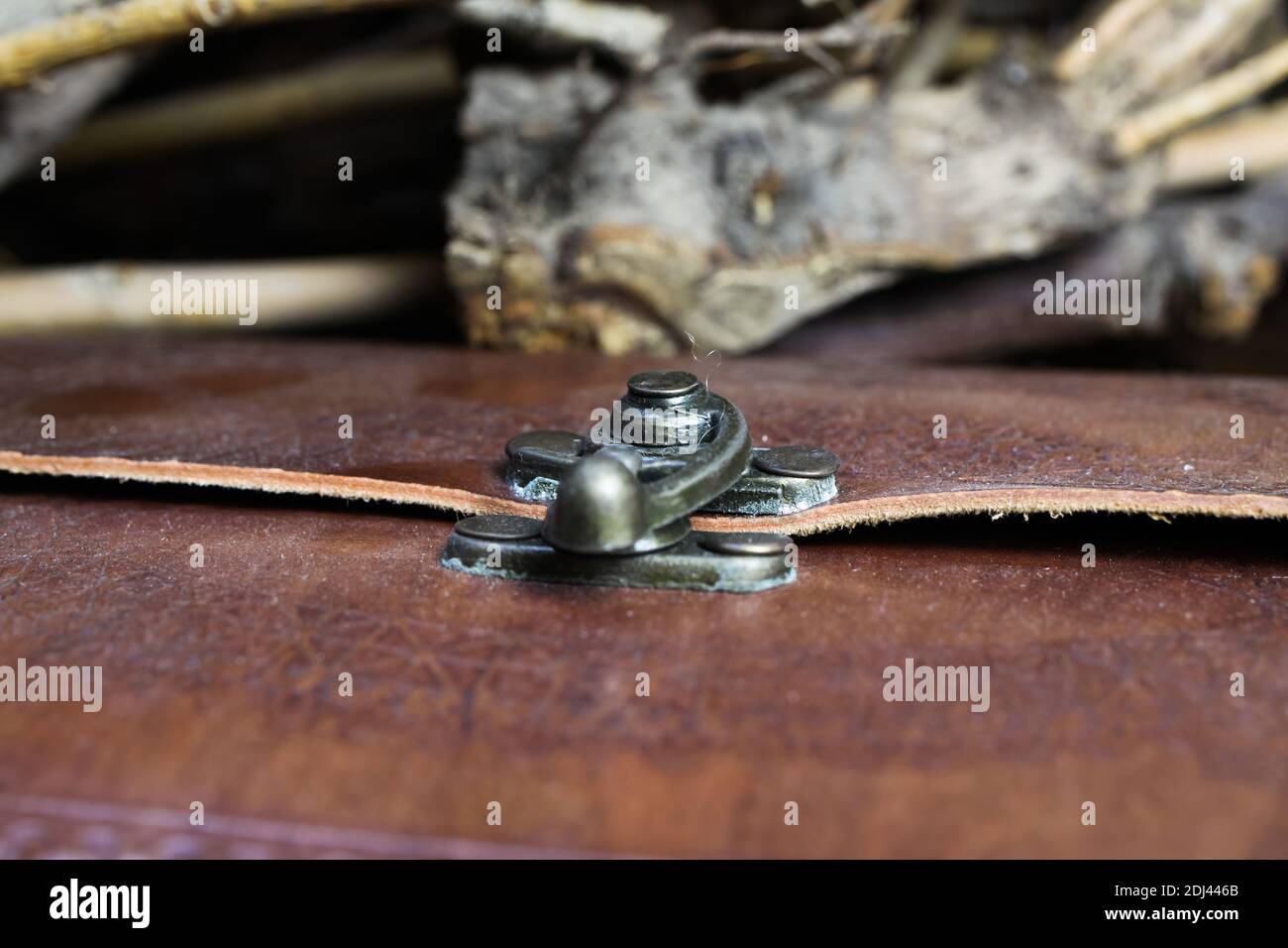 Macro primo piano di metallo blocco di diario libro con rilegatura in pelle marrone vintage (fuoco selettivo sulla parte posteriore del blocco) Foto Stock