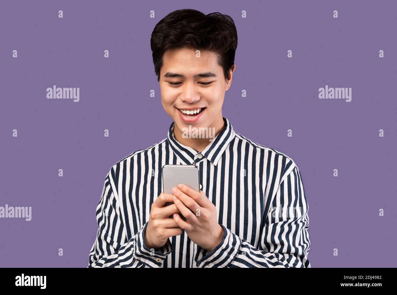 Sorridente giovane asiatico teen utilizzando il telefono cellulare in studio Foto Stock