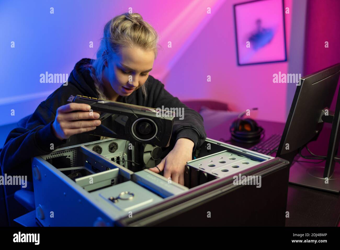 E-sport Gamer Girl Installazione di una nuova scheda video GPU in lei PC per videogame Foto Stock