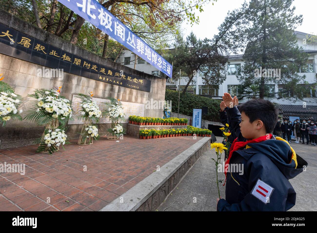 Nanjing, provincia cinese di Jiangsu. 13 Dicembre 2020. I membri dei giovani pionieri cinesi salutano di fronte a un monumento commemorativo delle vittime del massacro di Nanjing in un luogo di sepoltura di massa in occasione della settima giornata commemorativa nazionale a Nanjing, capitale della provincia di Jiangsu, nella Cina orientale, il 13 dicembre 2020. Credit: Du Yi/Xinhua/Alamy Live News Foto Stock