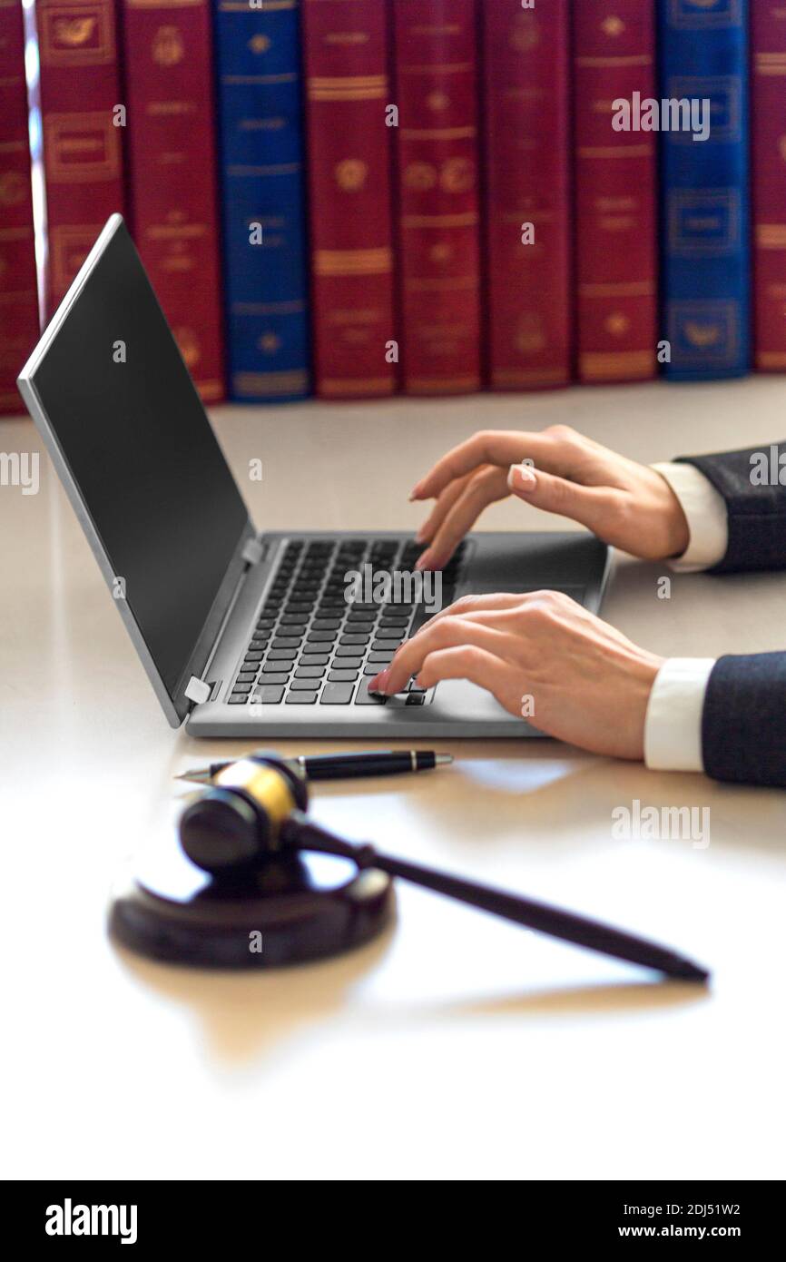 Le mani della donna dell'avvocato con il gavel giudiziario durante la consultazione in linea con il cliente. Ufficio legale. Foto Stock