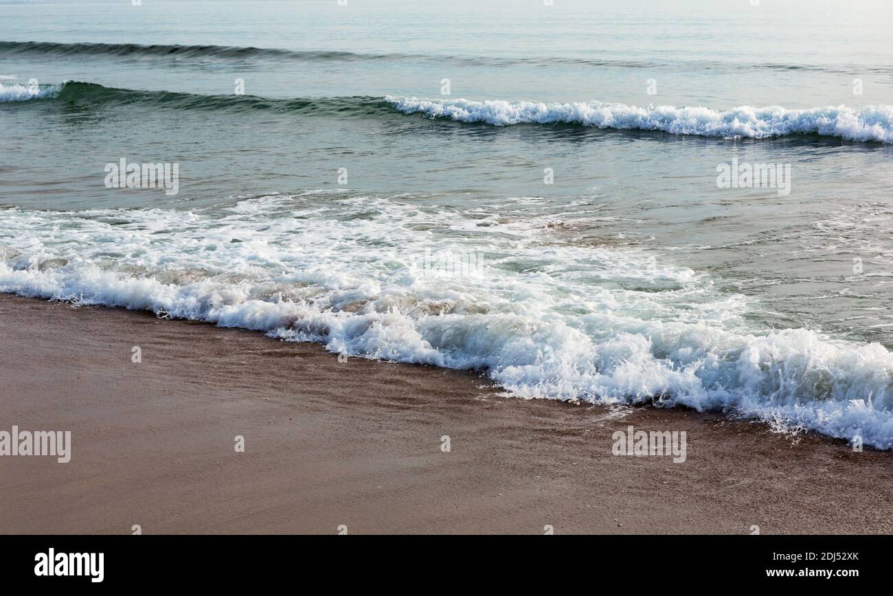 Onde del mare sulla spiaggia di sabbia con luce solare. Costa del mare sabbia bagnata. Mare del Giappone. Composizione naturale. Foto Stock