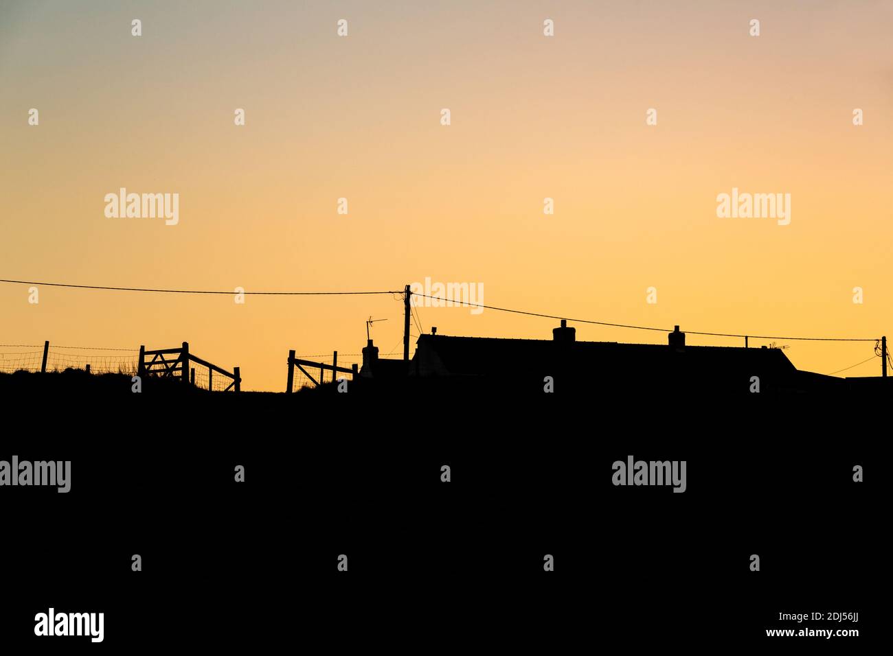 Silhouette di case con un cielo arancione Foto Stock