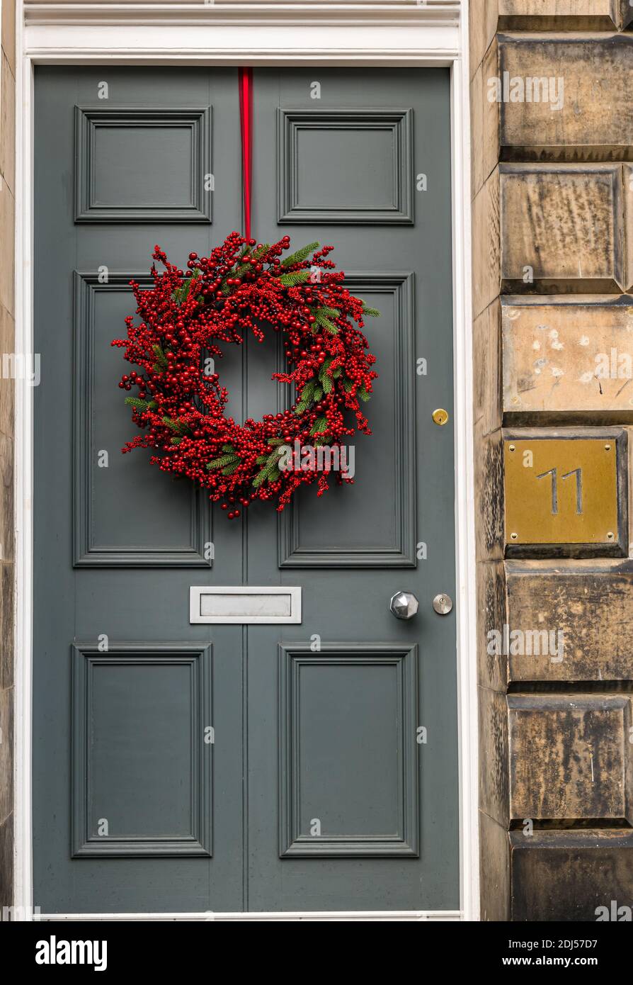 Corona di Natale decorativa sulla porta anteriore pannellata numero 11 della residenza georgiana, Edinburgh New Town, Scozia, UK Foto Stock