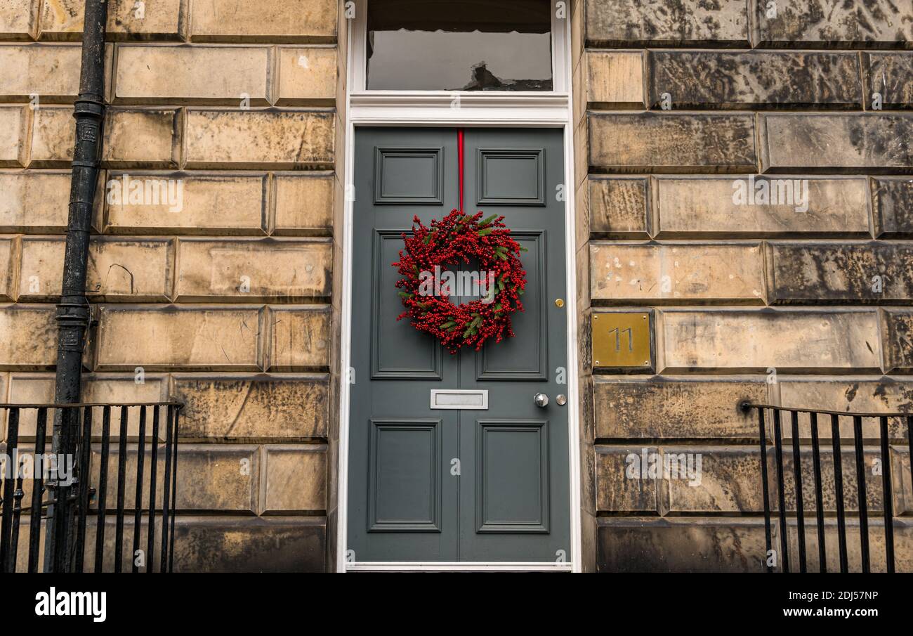 Corona di Natale decorativa sulla porta anteriore pannellata numero 11 della residenza georgiana, Edinburgh New Town, Scozia, UK Foto Stock
