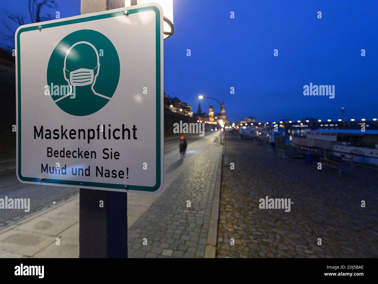 Dresda, Germania. 13 Dicembre 2020. Un cartello che indica che le maschere sono obbligatorie è appeso su un lampione sulla terrazza a riva. Per contenere la pandemia di Corona, la Sassonia sta imponendo un blocco da lunedì e sta chiudendo la vita pubblica. Credit: Robert Michael/dpa-Zentralbild/dpa/Alamy Live News Foto Stock