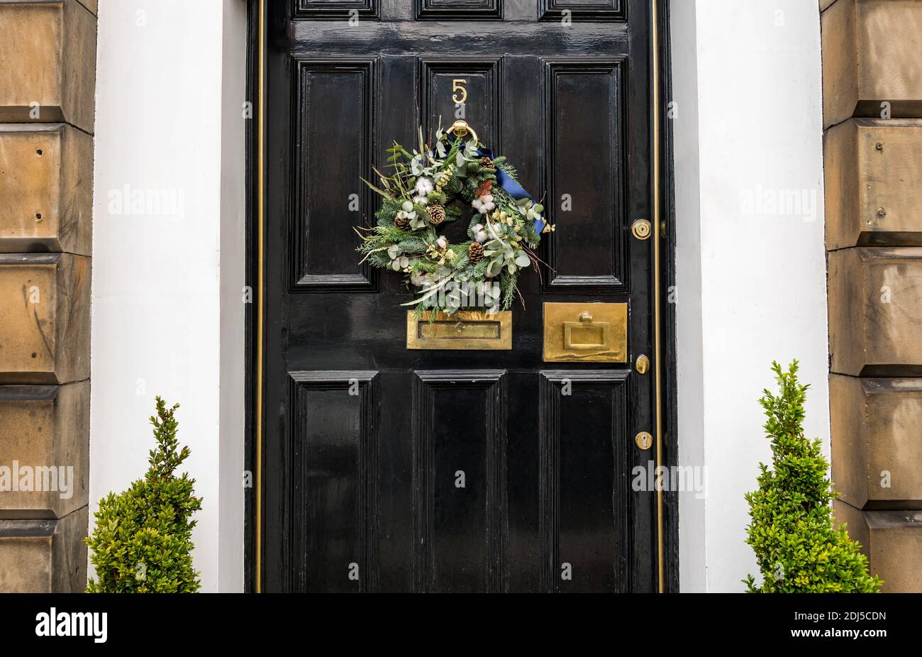 Corona di Natale decorativa sulla porta anteriore pannellata della residenza georgiana, Edimburgo New Town, Scozia, Regno Unito Foto Stock