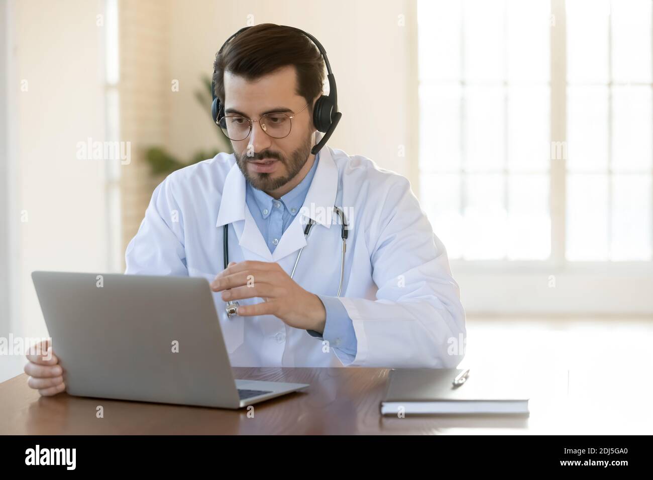 Il medico di sesso maschile ha video chiamata di consultazione con il paziente Foto Stock