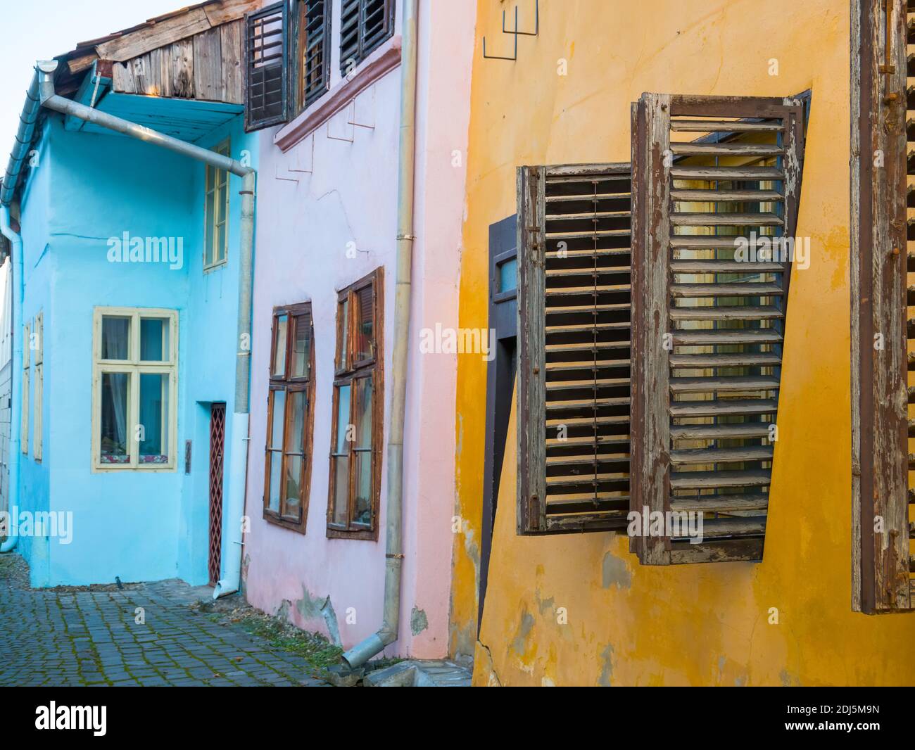 Primo piano con vecchie case colorate e finestre in legno persiane nella Cittadella di Sighisoara, Romania. Foto Stock