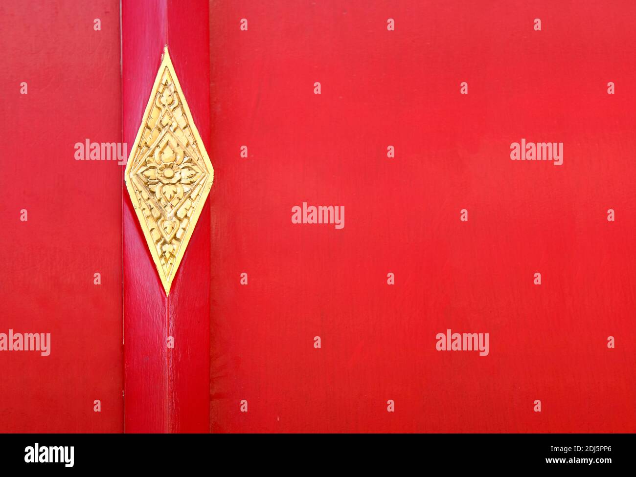 Porta rossa con elementi metallici in stile asiatico. Cancello di legno rosso con dettagli dorati. Porta con ornamento floreale thailandese. Foto Stock
