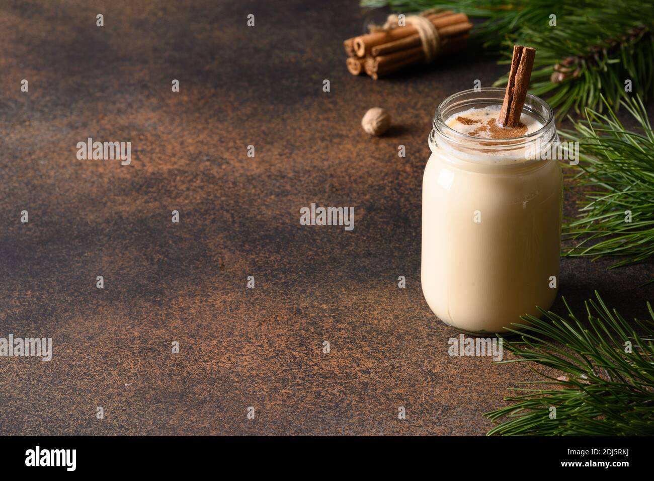 Festa di Natale eggnog con cannella su sfondo marrone. Primo piano. Spazio di copia. Foto Stock