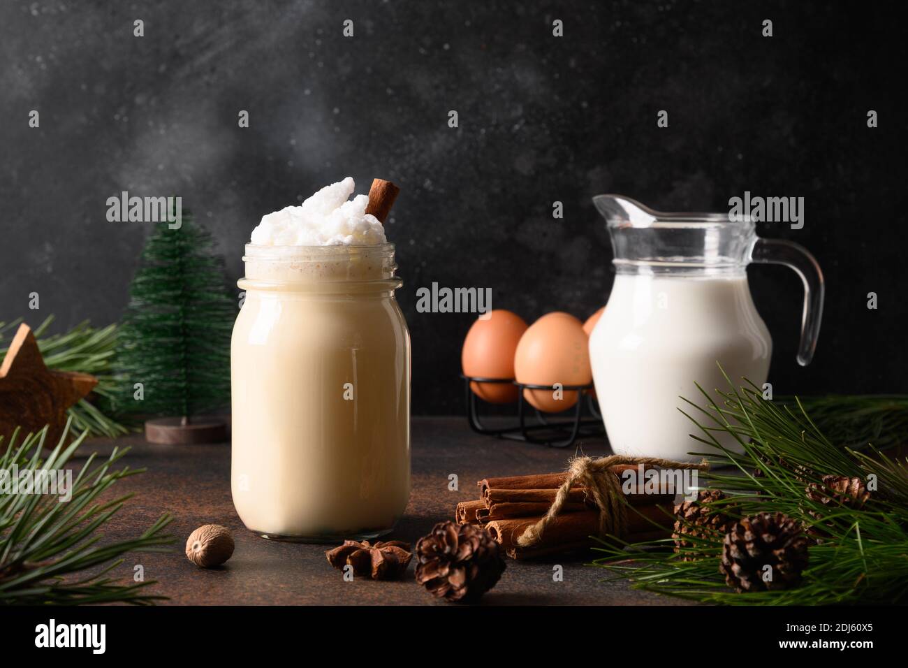 Eggnog di Natale in vasetto di muratore con ingredienti su sfondo marrone scuro. Primo piano. Foto Stock