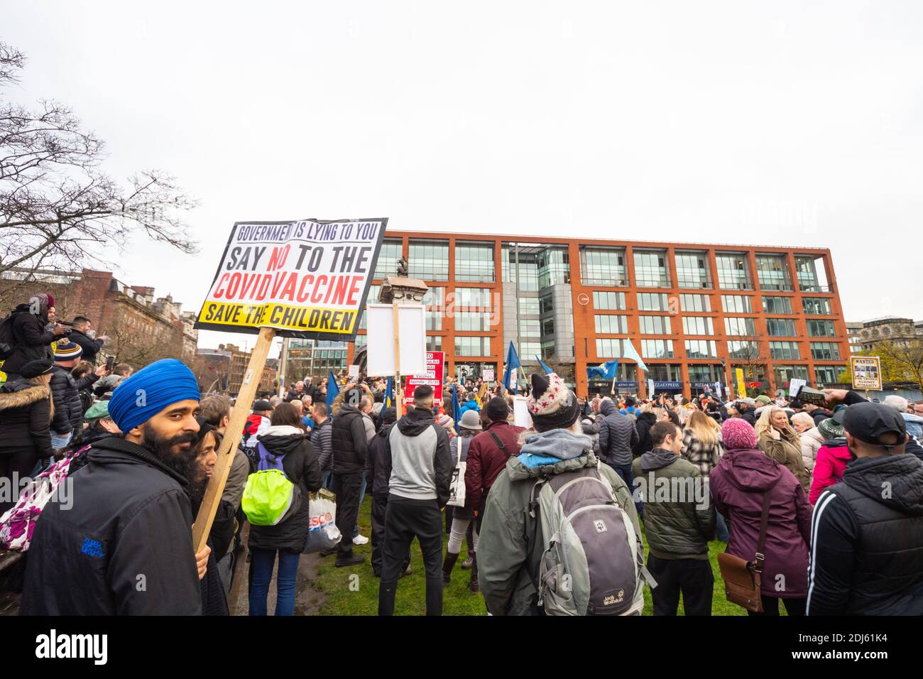 Manchester sab 12 dicembre 2020. Freedom rally/anti COVID-19 restrizioni protesta, Piccadilly giardini. Il placard di vaccino Covid si è tenuto in su fra una folla Foto Stock