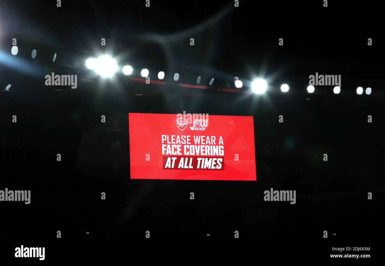 Lo schermo gigante recita "ti preghiamo di indossare sempre una copertura facciale" durante la partita della Premier League all'Emirates Stadium di Londra. Foto Stock