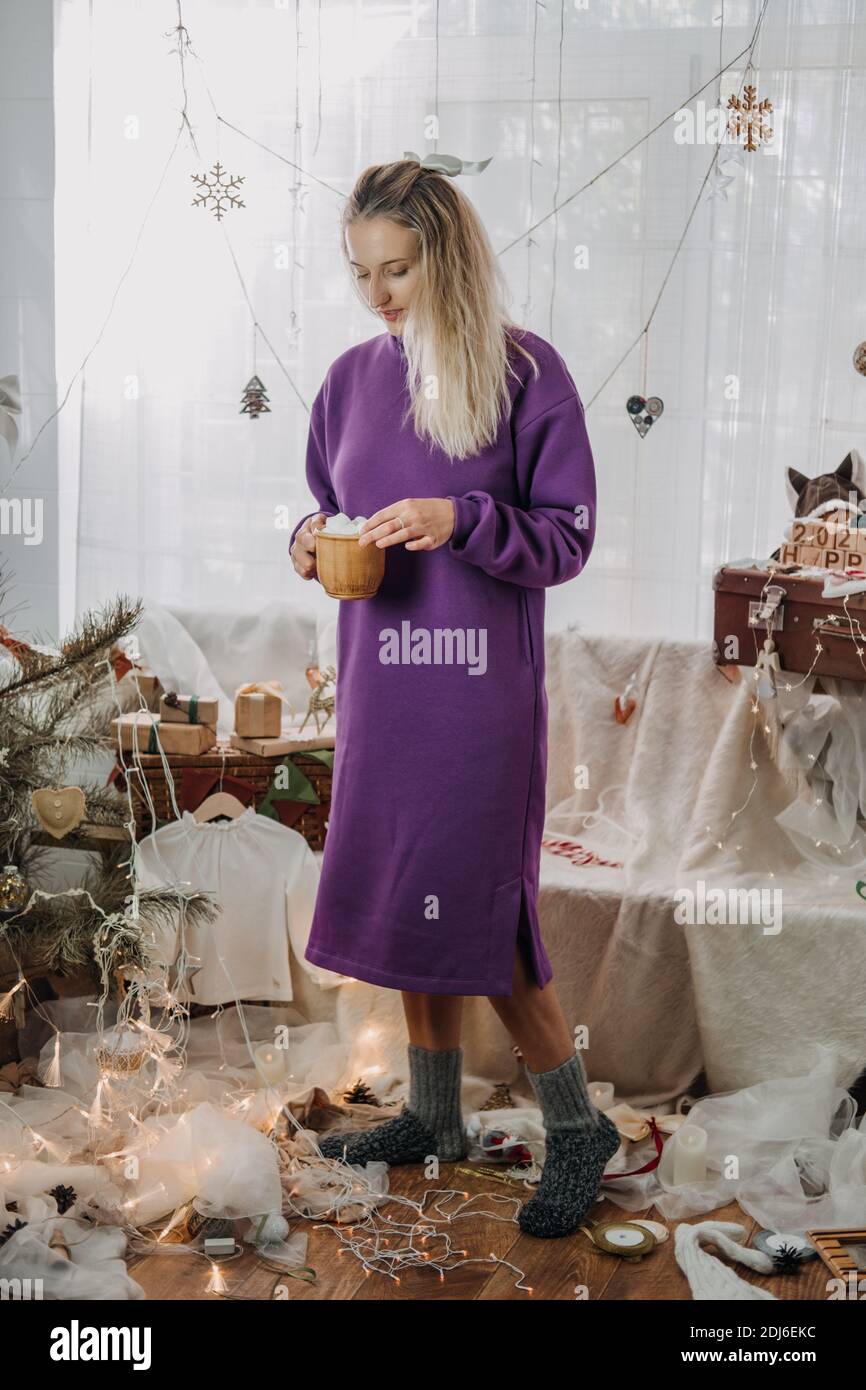 Natale decorazione a casa. Giovane donna che mette ornamenti sull'albero di Natale, mettendo le luci. Hristmas di bilancio idee di arredamento domestico Foto Stock