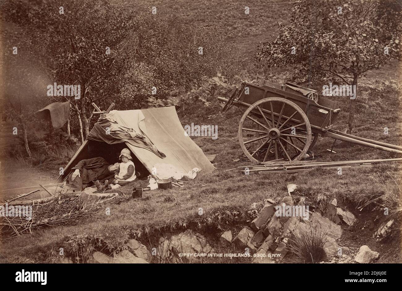 Campo di Gipsy nelle Highlands, G. W. Wilson, 1823–1893, inglese, ca. 1880, stampa albume da collodio umido negativo su carta sottile, liscia, crema wove, foglio: 7 1/2 × 11 1/4 pollici (19.1 × 28.6 cm), campi (insediamenti temporanei), carrello, bambino, genere soggetto, erba, uomo, rocce (forme di terra), tenda, alberi Foto Stock