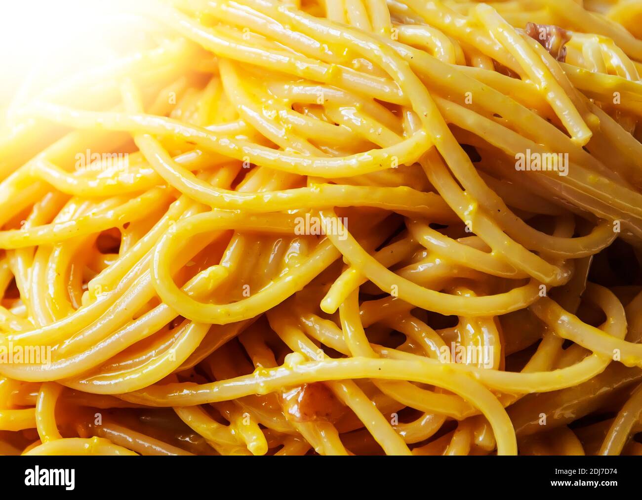 Vista ravvicinata degli spaghetti con salsa di carbonara. Ricetta romana tipica con uova, pancetta, pecorino romano e parmigiano. Cucina e ricette tipiche italiane Foto Stock