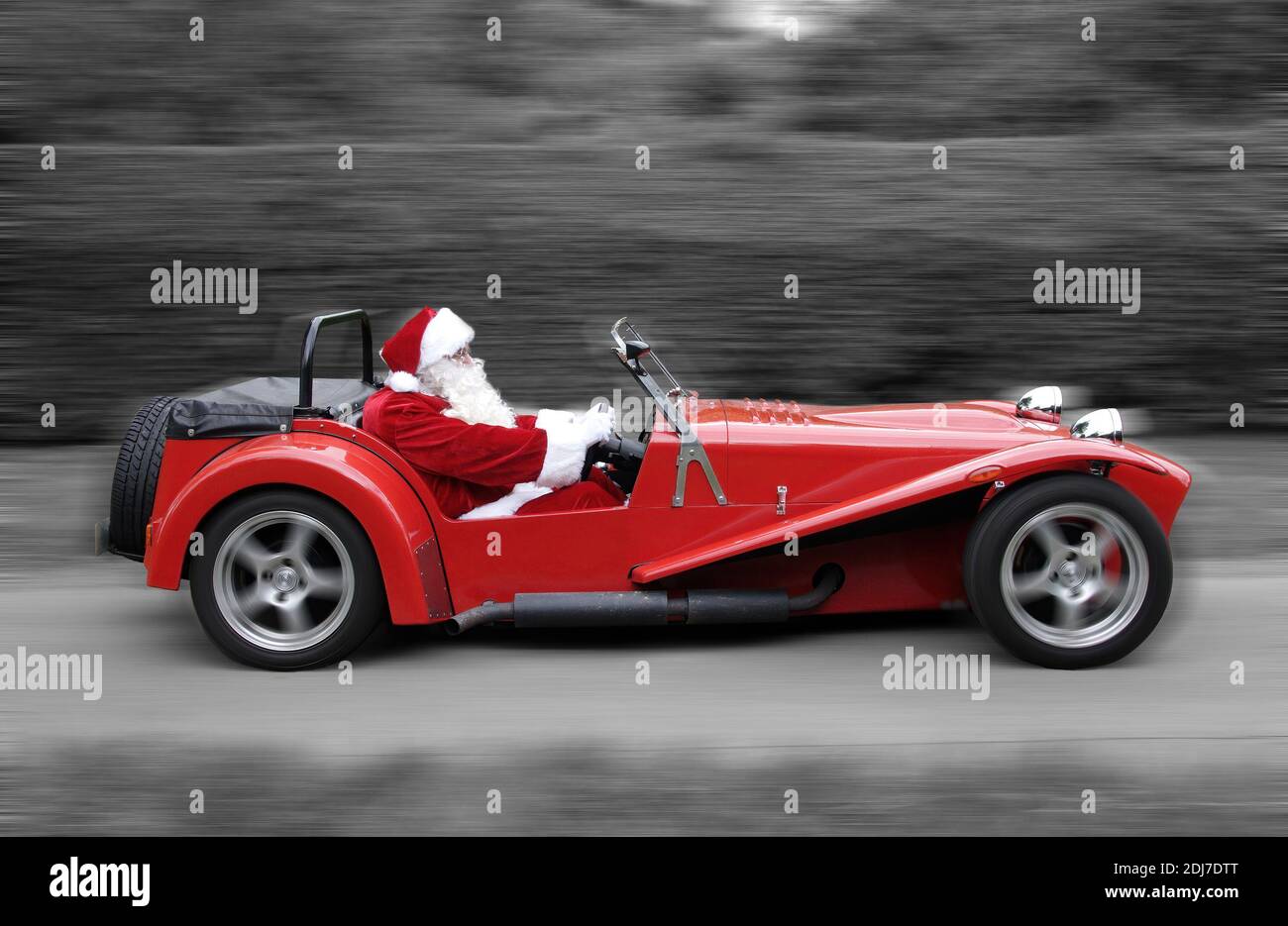 Padre Natale alla guida di un'auto sportiva rossa (immagine della scheda di Natale) Foto Stock
