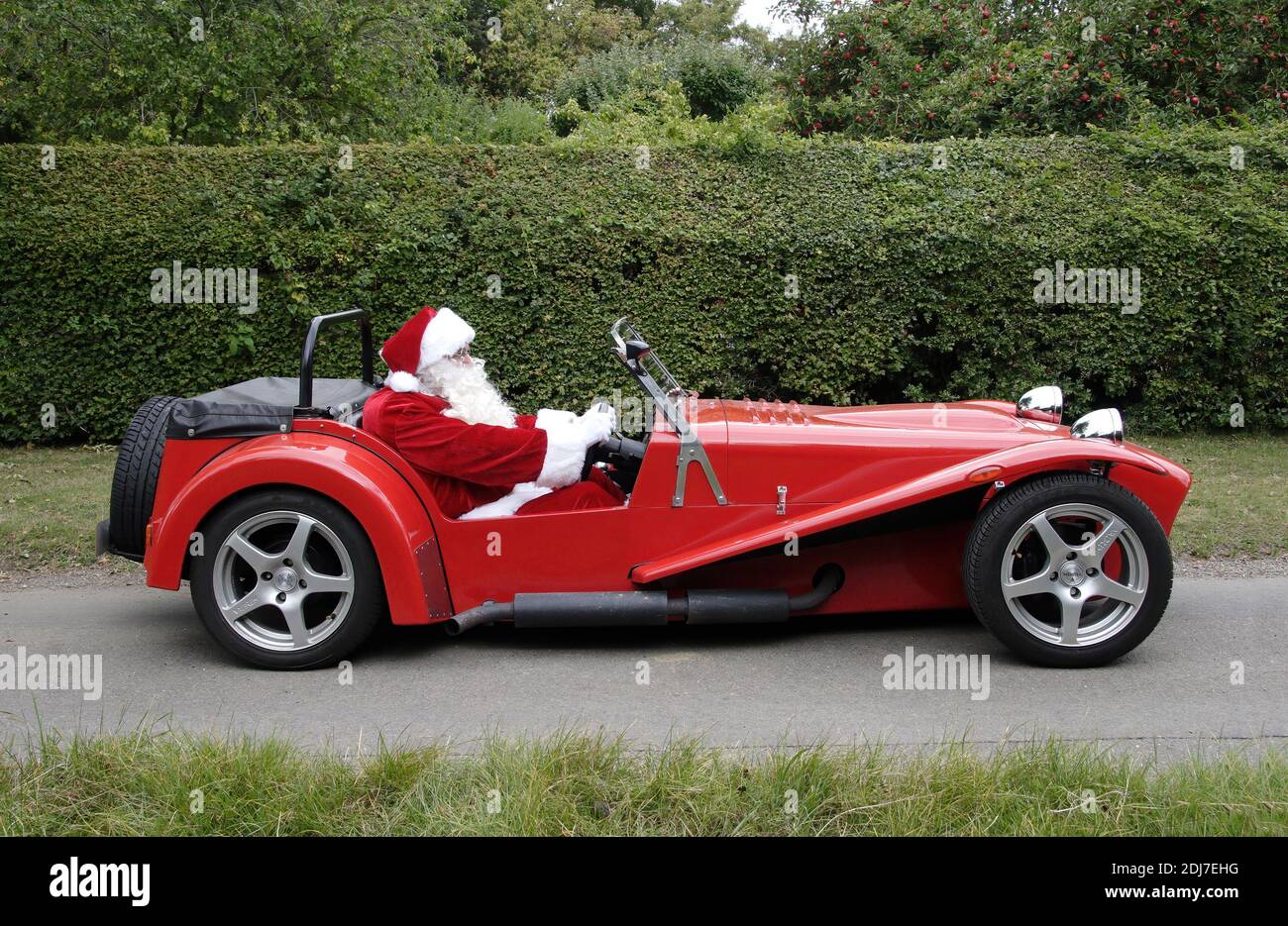 Padre Natale alla guida di una vettura sportiva rossa grande immagine per Cartolina di Natale Foto Stock