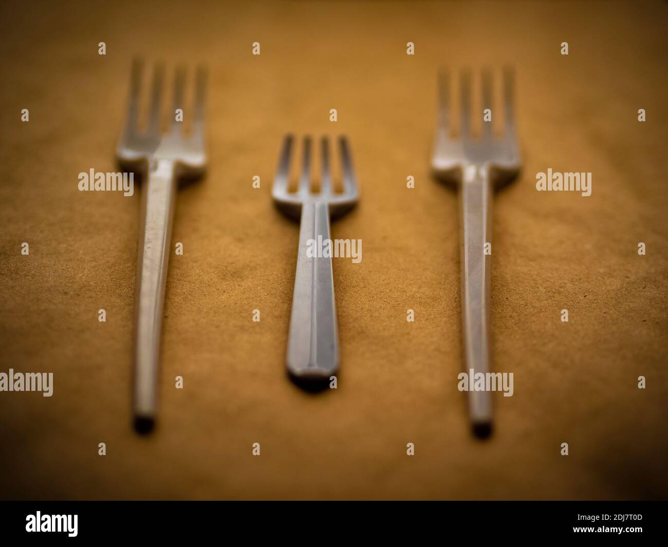 disposable tableware, red spoons forks knives on a yellow background top view Foto Stock