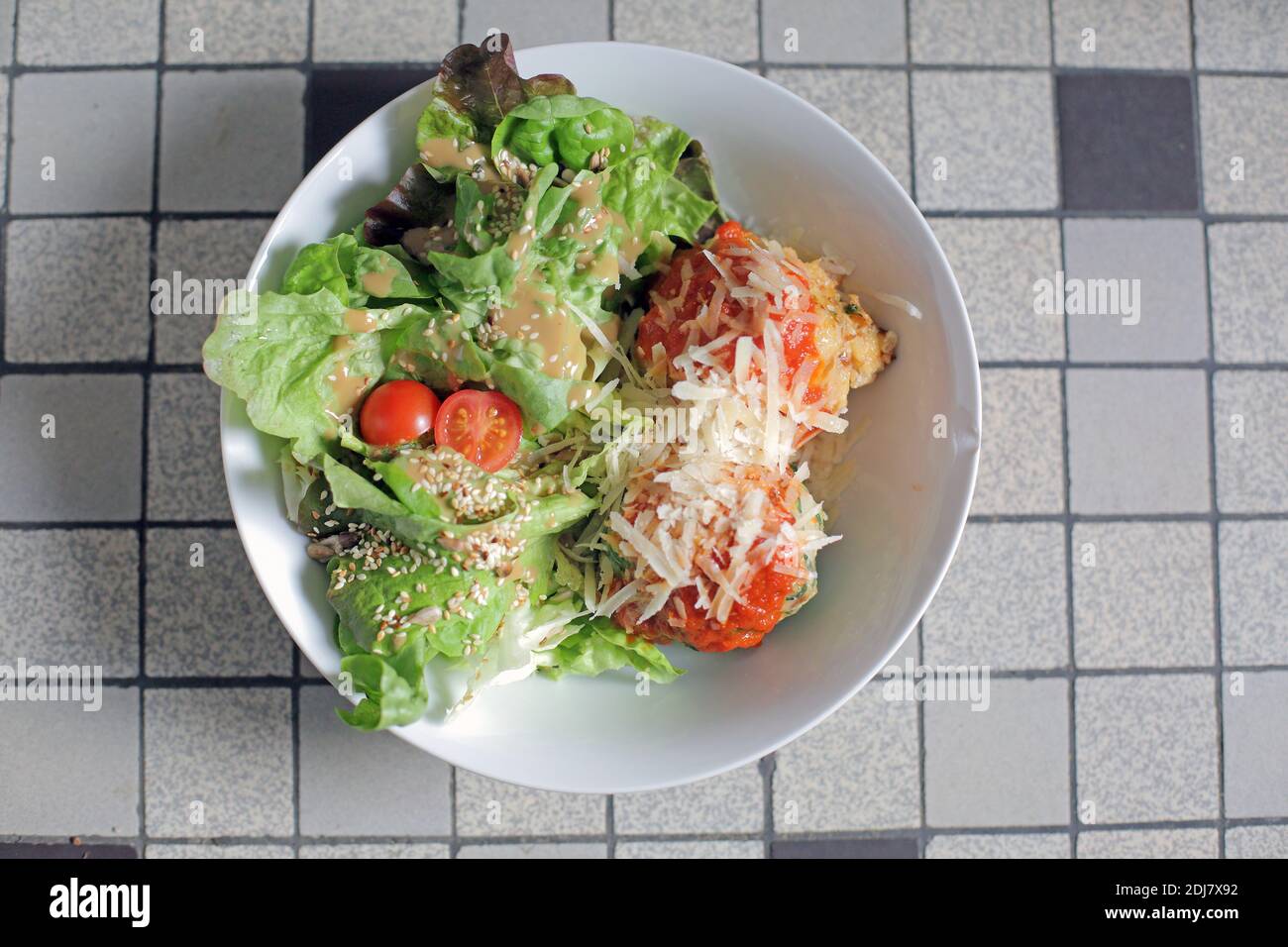 Parmigiana di melanzane, pomodoro, mozzarella e parmigiano grattugiato con insalata fresca in un piatto Foto Stock