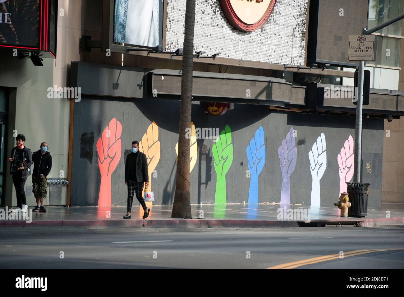 Persone con maschere Covid vicino a un murale su Hollywood blvd. Dedicato a transgender persone di colore Foto Stock