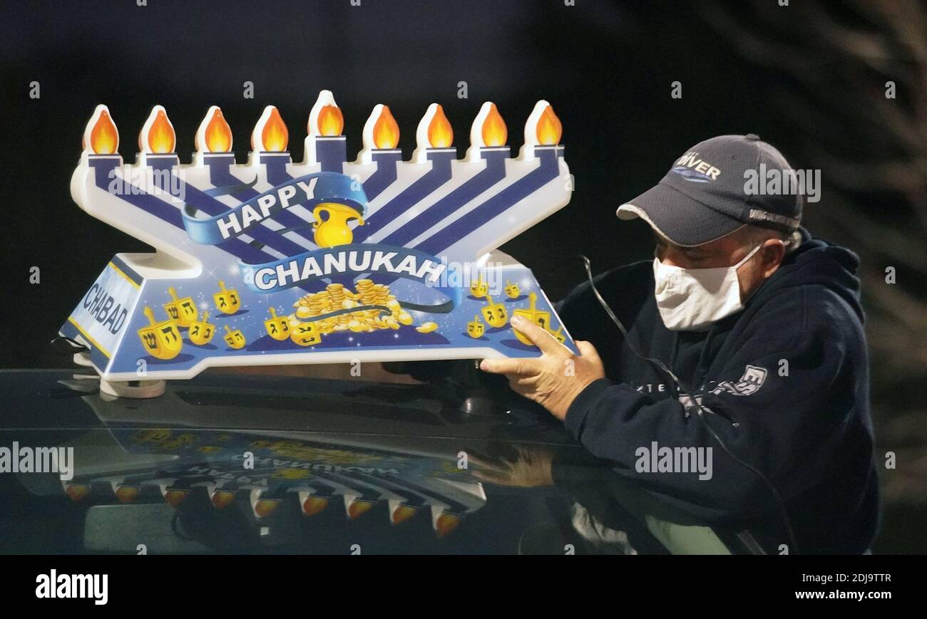 Chesterfield, Stati Uniti. 13 Dicembre 2020. Un volontario posiziona un menorah Hanukkah su un'auto, preparandosi per la sfilata Hanukkah a Chesterfield, Missouri, domenica 13 dicembre 2020. Quasi 100 automobili sfilano attraverso il quartiere di Chesterfield, Missouri, con i menorah lampanti in plastica sulle loro auto, e la musica Hanukkah che suona sulle loro radio. Photo by Bill Greenblatt/UPI Credit: UPI/Alamy Live News Foto Stock