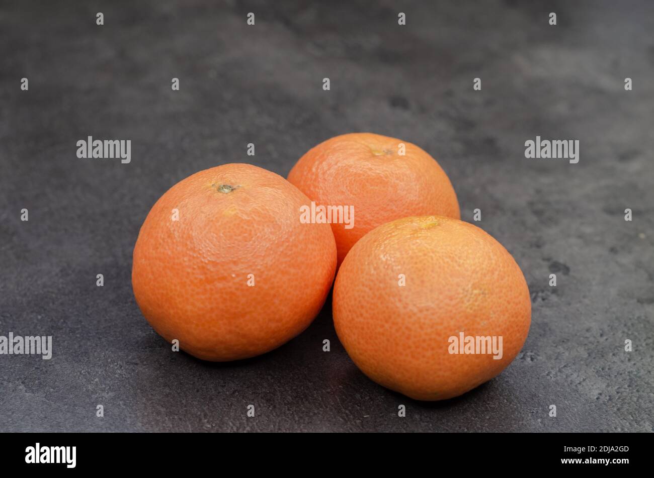Primo piano di tre arance fresche sulla tavola Foto Stock