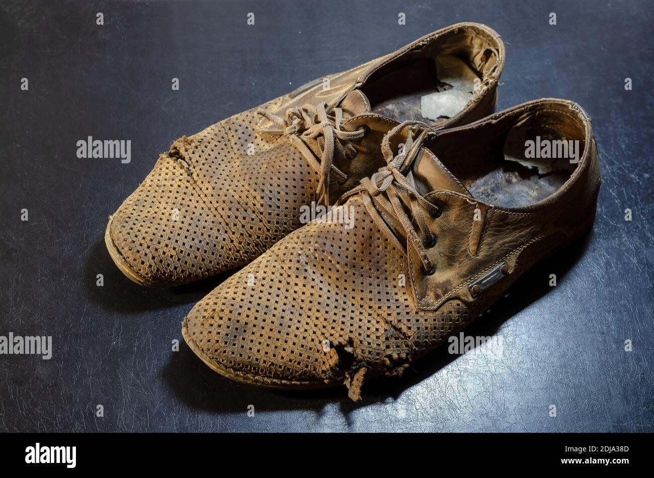 Vecchie scarpe estive gialle lacerate su sfondo nero. Un paio di scarpe in  pelle da uomo molto indossate Foto stock - Alamy