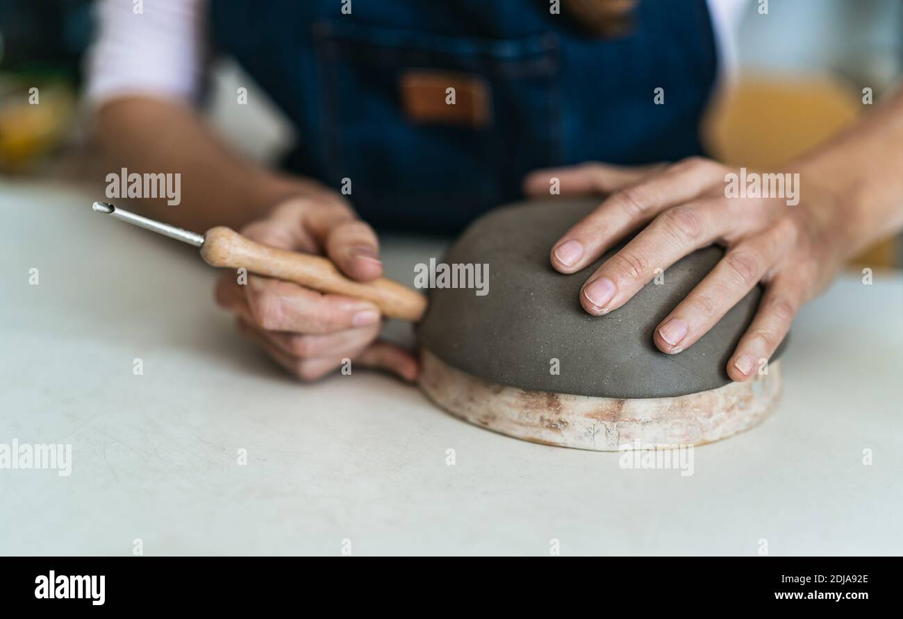 Primo piano femmina vasaio modellante creta ciotola in officina - Lavoro artigianale e concetto di artigianato creativo Foto Stock