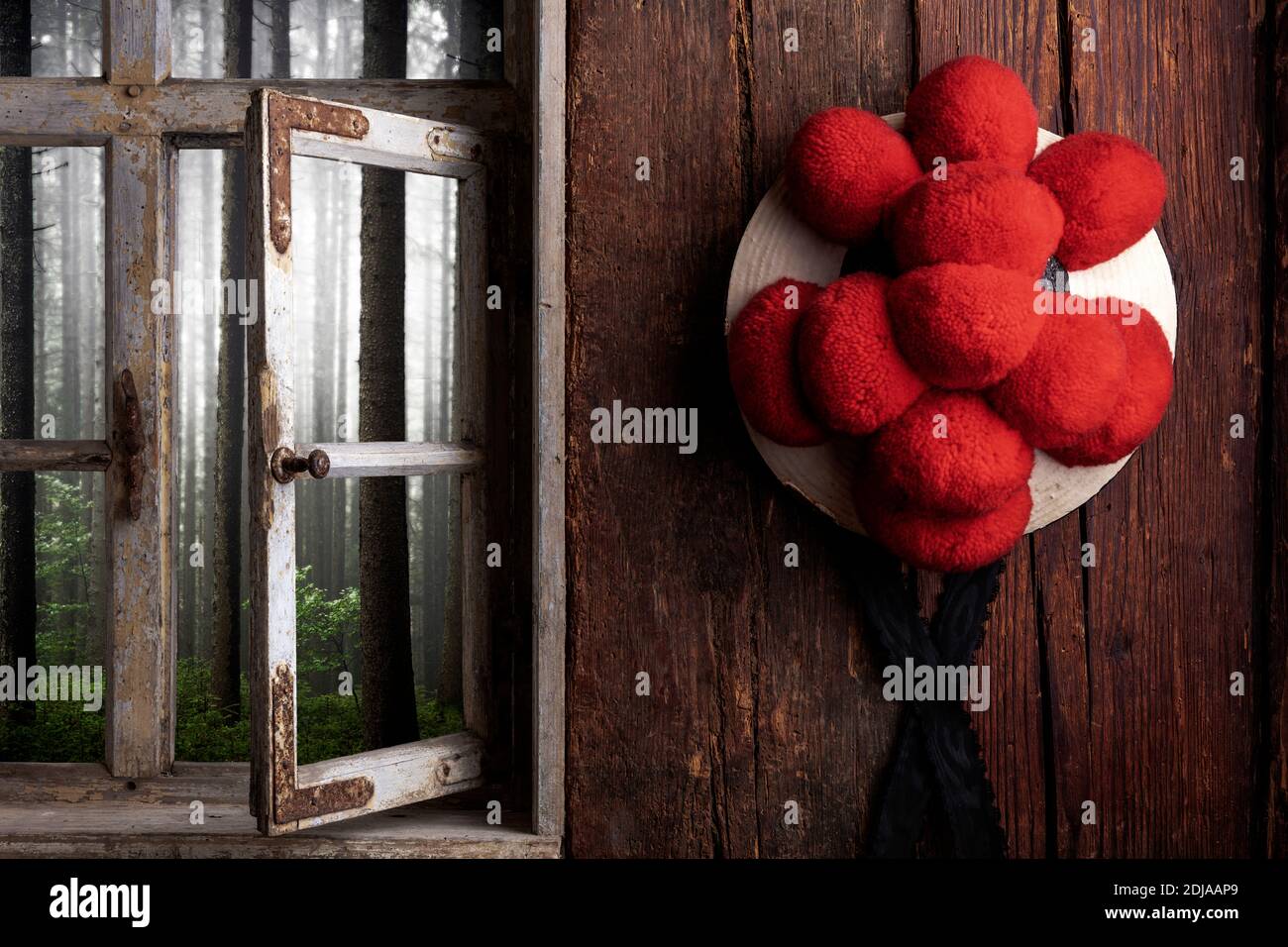 Vista da una casa colonica rustica attraverso una finestra in legno nella foresta nebbiosa Foto Stock